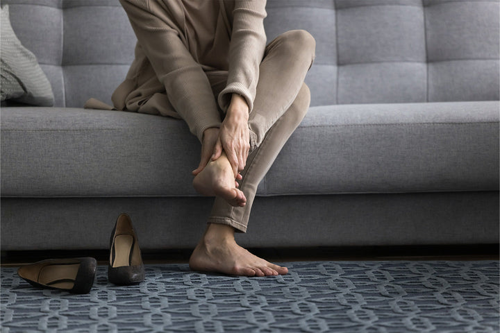 Bild på kvinna som håller sig om sin häl
