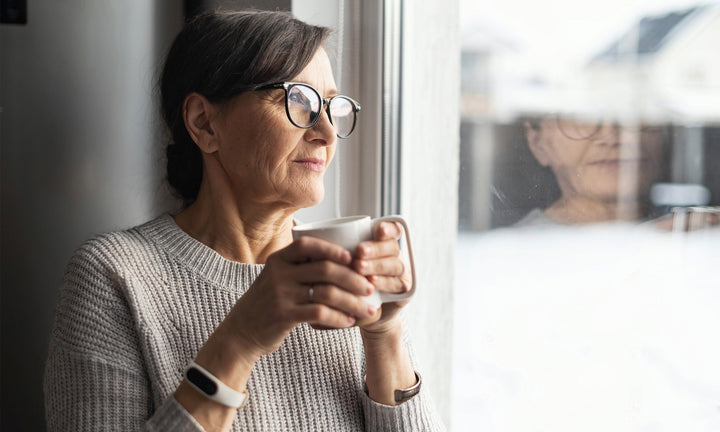Äldre kvinna håller i en kaffekopp